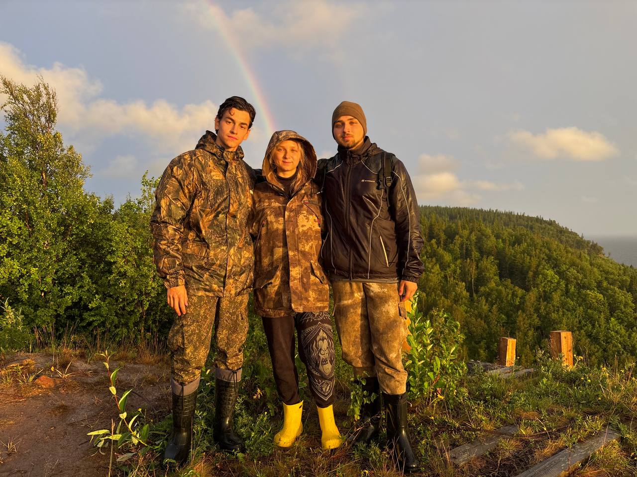 Three of us on the cliff with a rainbow behind