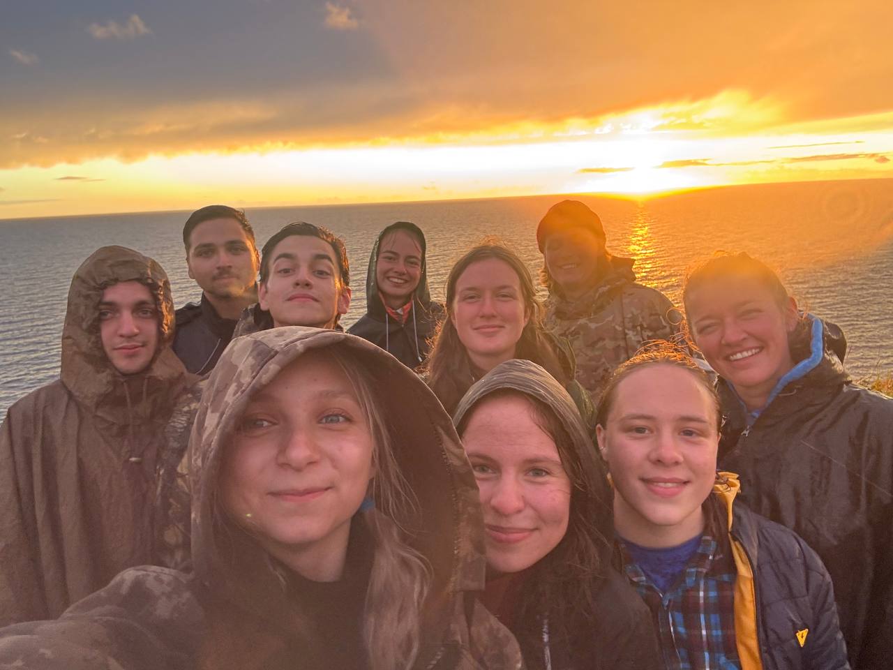 Group selfie of the team at sunset