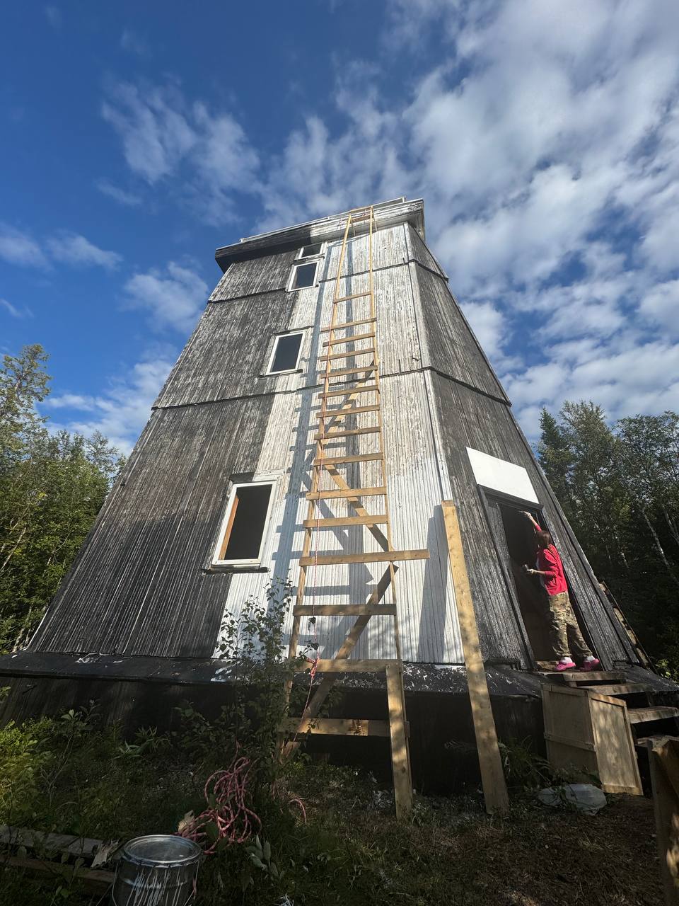 The wooden lighthouse tower with new boards and a ladder