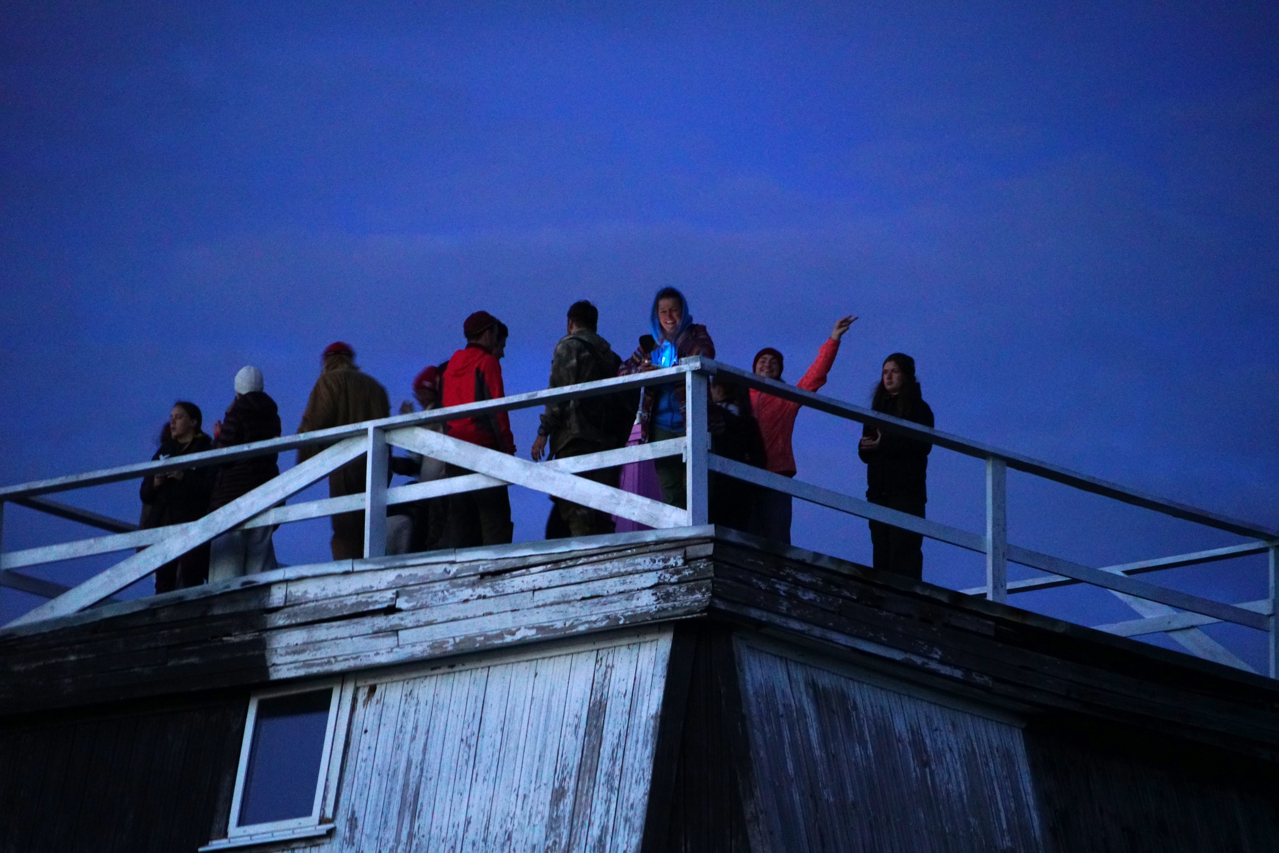 Expedition members on the lighthouse gallery at dusk